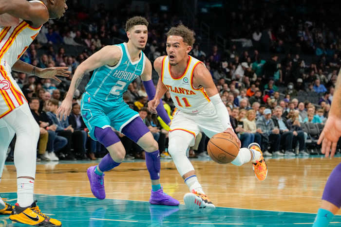 Hawks guard Trae Young dribbles past Hornets guard LaMelo Ball.